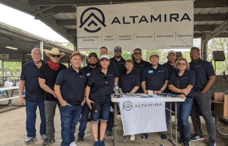 a group of Altamira's team members standing in front of a sign that says Altamira.