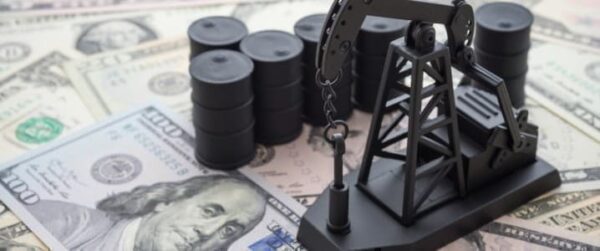 a model of an oil pump is sitting on top of a pile of money.